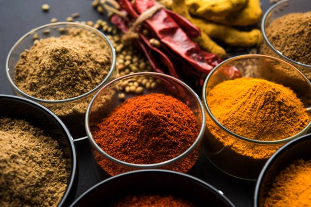 Indian colourful spices. Group photo of four basic Indian spices like raw red chilli, turmeric, coriander and cumin powder. selective focus